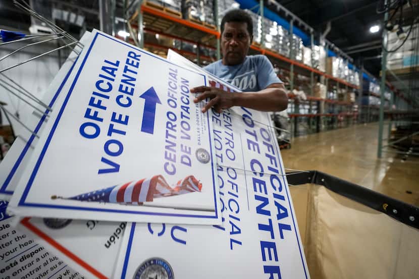 An election worker unloads signs used at polling places after election materials were...