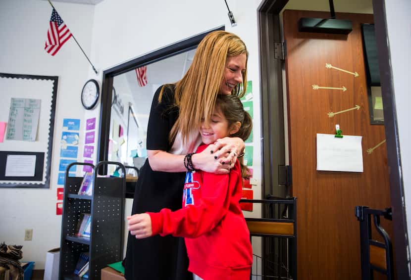 Momentous Institute executive director Michelle Kinder hugs fourth grader Rebecca before...