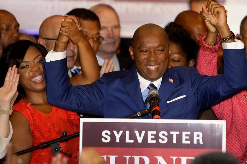 Mayoral candidate Sylvester Turner, center, raises hands with his daughter, Ashley Turner,...