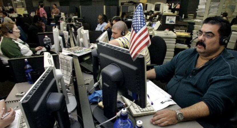 911 call taker Frank Gomez (right) is shown on duty in 2006 in Dallas City Hall. The Dallas...