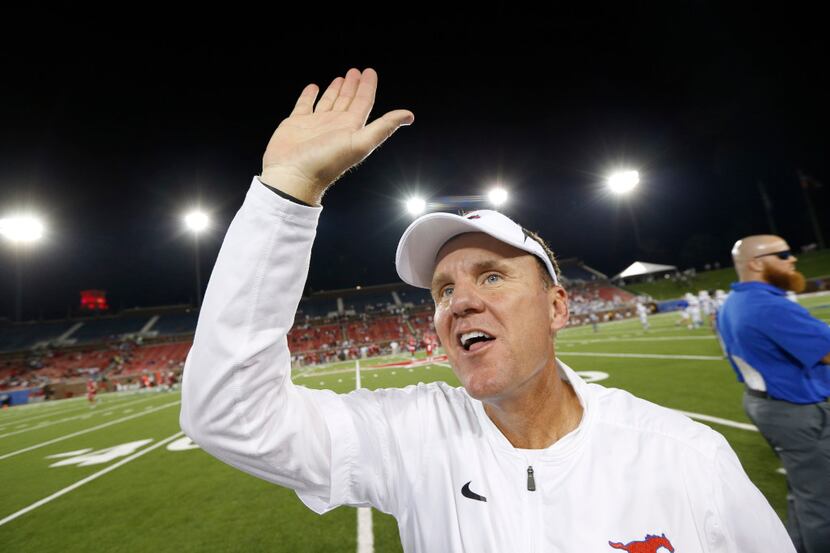Southern Methodist Mustangs head coach Chad Morris high fives his team after winning again...