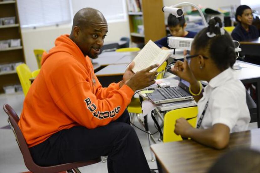 
North Dallas High School athletic director Carlton Dixon reads a book to fourth-grade...