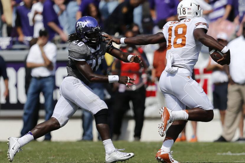 Texas Longhorns quarterback Tyrone Swoopes (18) tries to hold off TCU Horned Frogs safety...