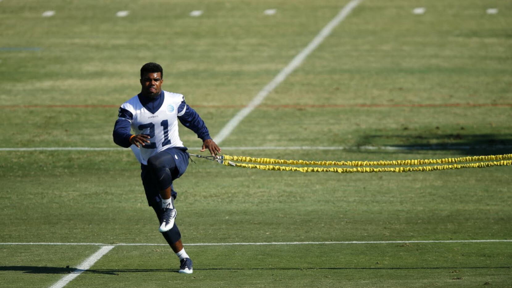 Dallas Cowboys running back Ezekiel Elliott (21) uses a bungee to work out with as he nurses...