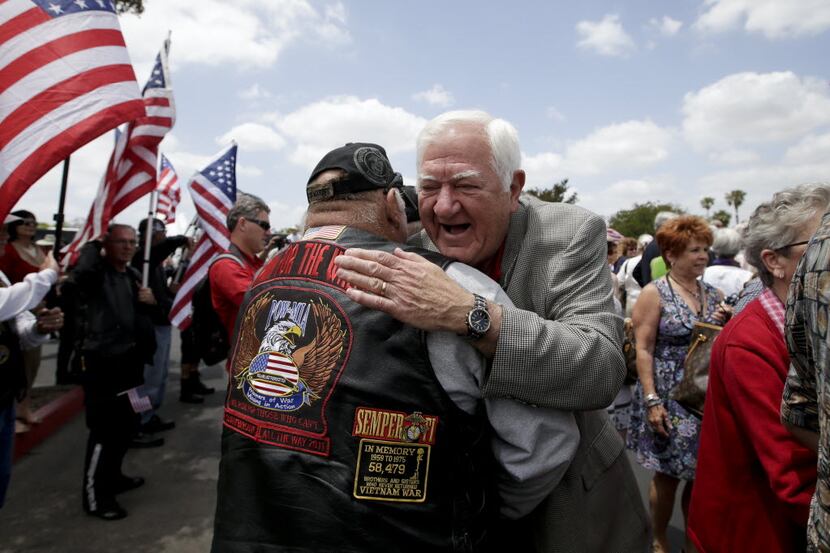 Former Vietnam POW Orson Swindle, right, gets a hug from Jim Janeway as he arrives to...