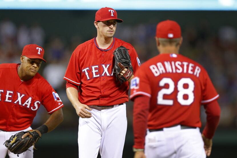 Texas Rangers relief pitcher Tanner Scheppers (center) leaves the game in the eighth inning...
