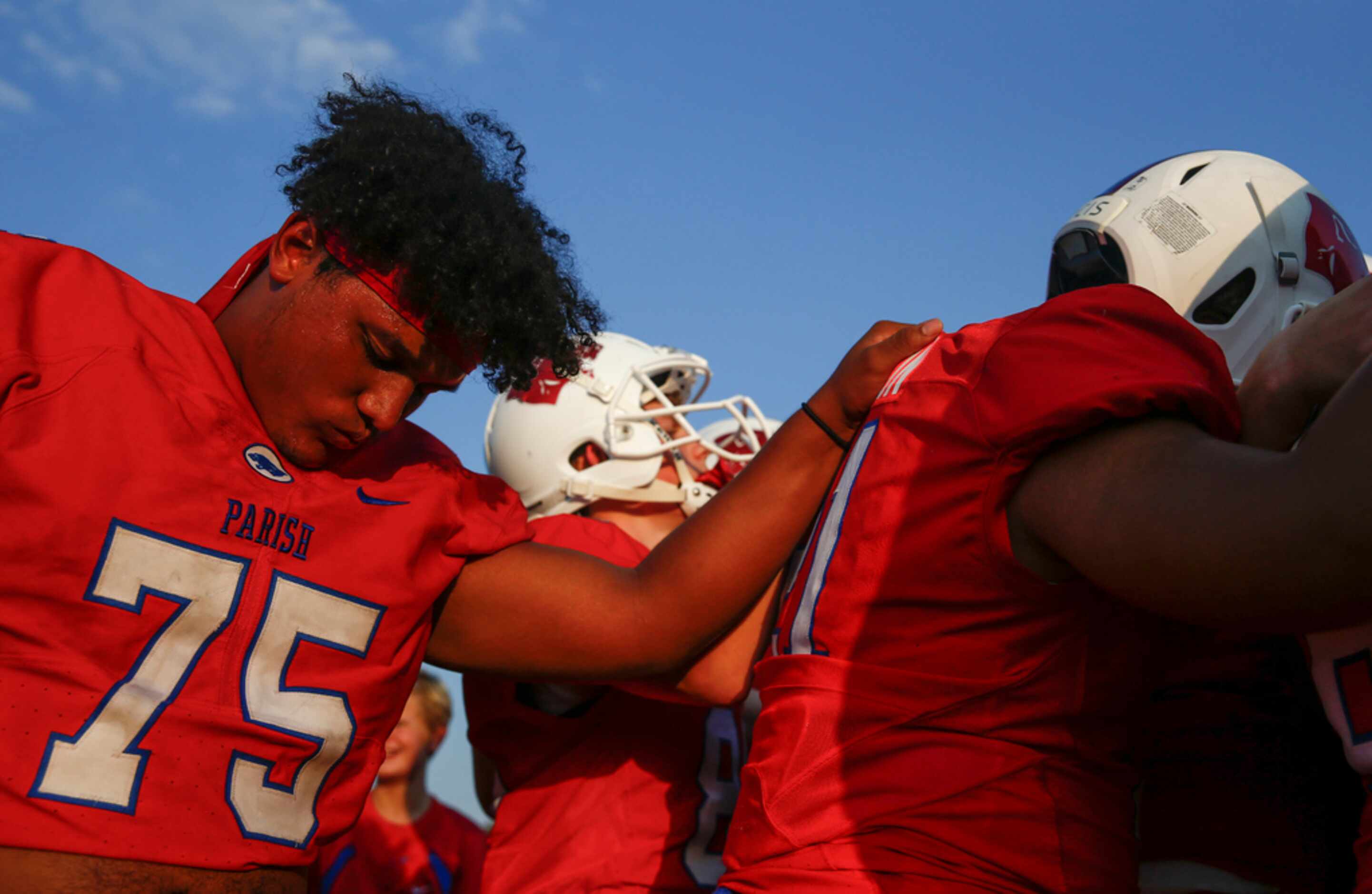 Parish Episcopal lineman Noah Richards (75) lowers his head for a prayer prior to a high...