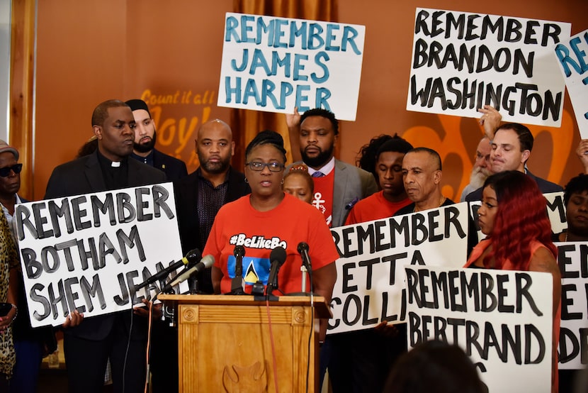 Pastor Michael W. Waters, left, listens as Allison Jean, Botham Shem Jean's mother, speaks...