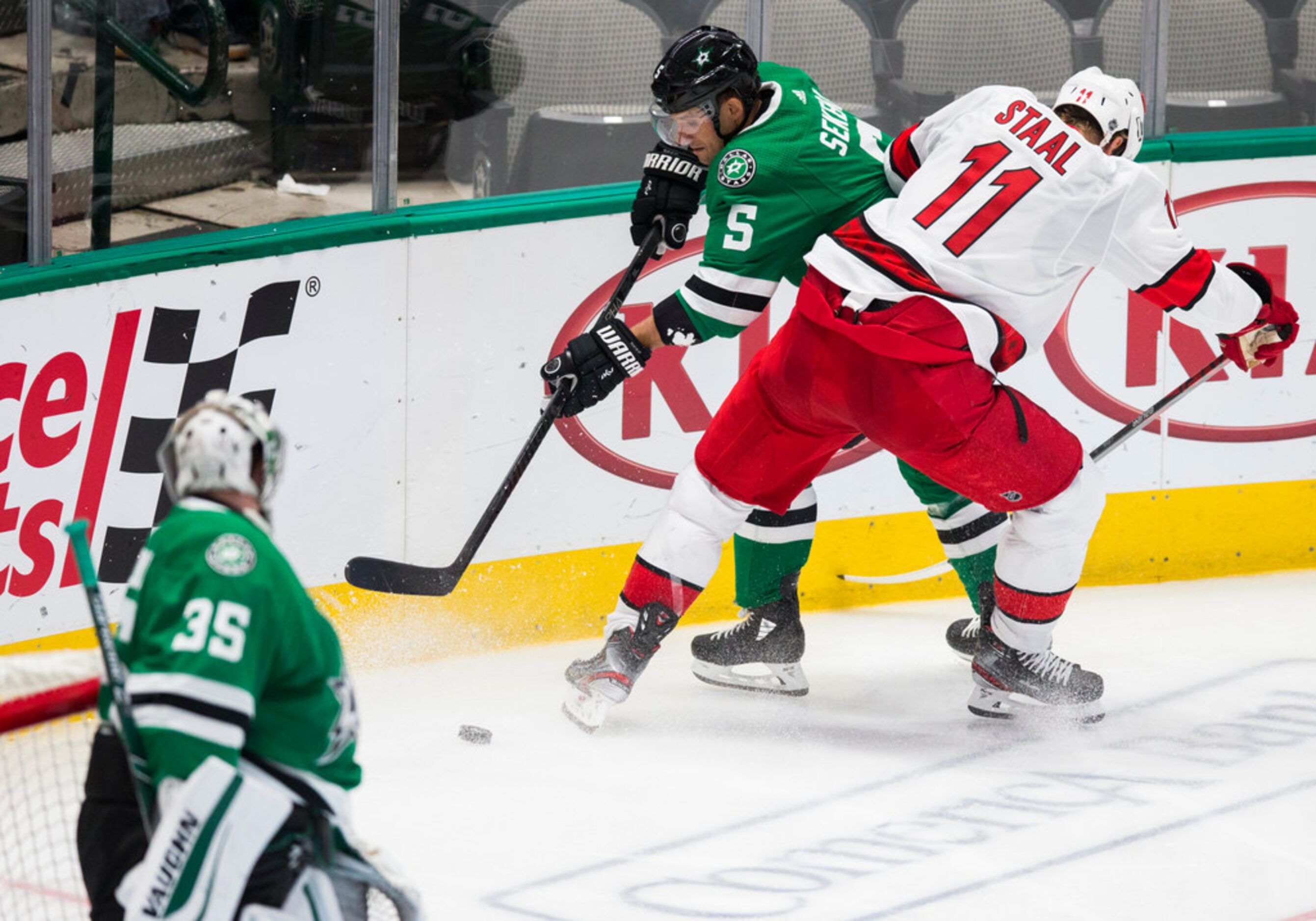 Dallas Stars defenseman Andrej Sekera (5) is hit by Carolina Hurricanes center Jordan Staal...