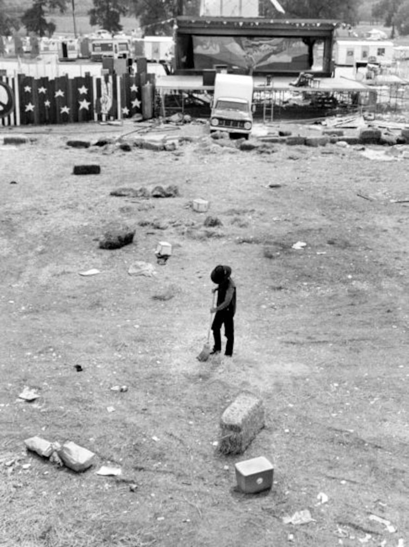 An unknown person cleans up in front of the main stage area a few days after the festival. ...