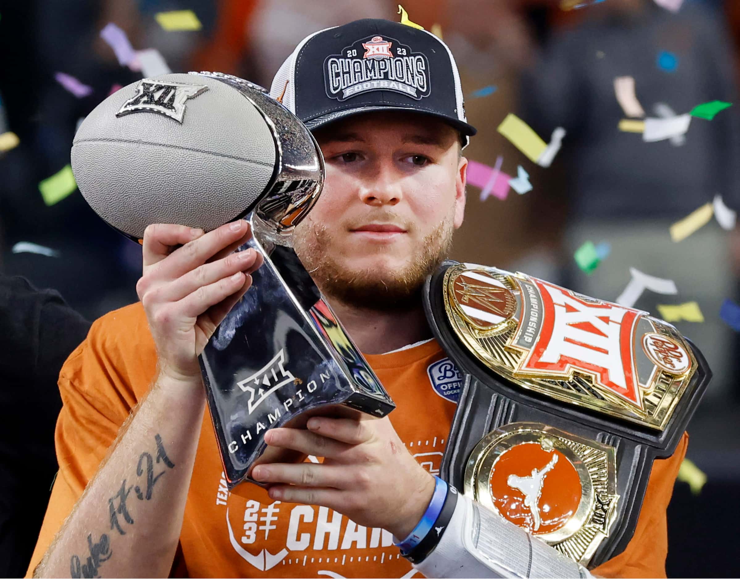 Texas Longhorns quarterback Quinn Ewers hoists the Big 12 Championship trophy after...