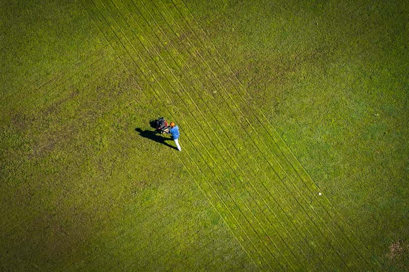 A man cuts grass on Tuesday, March 24, 2020 in Plano.