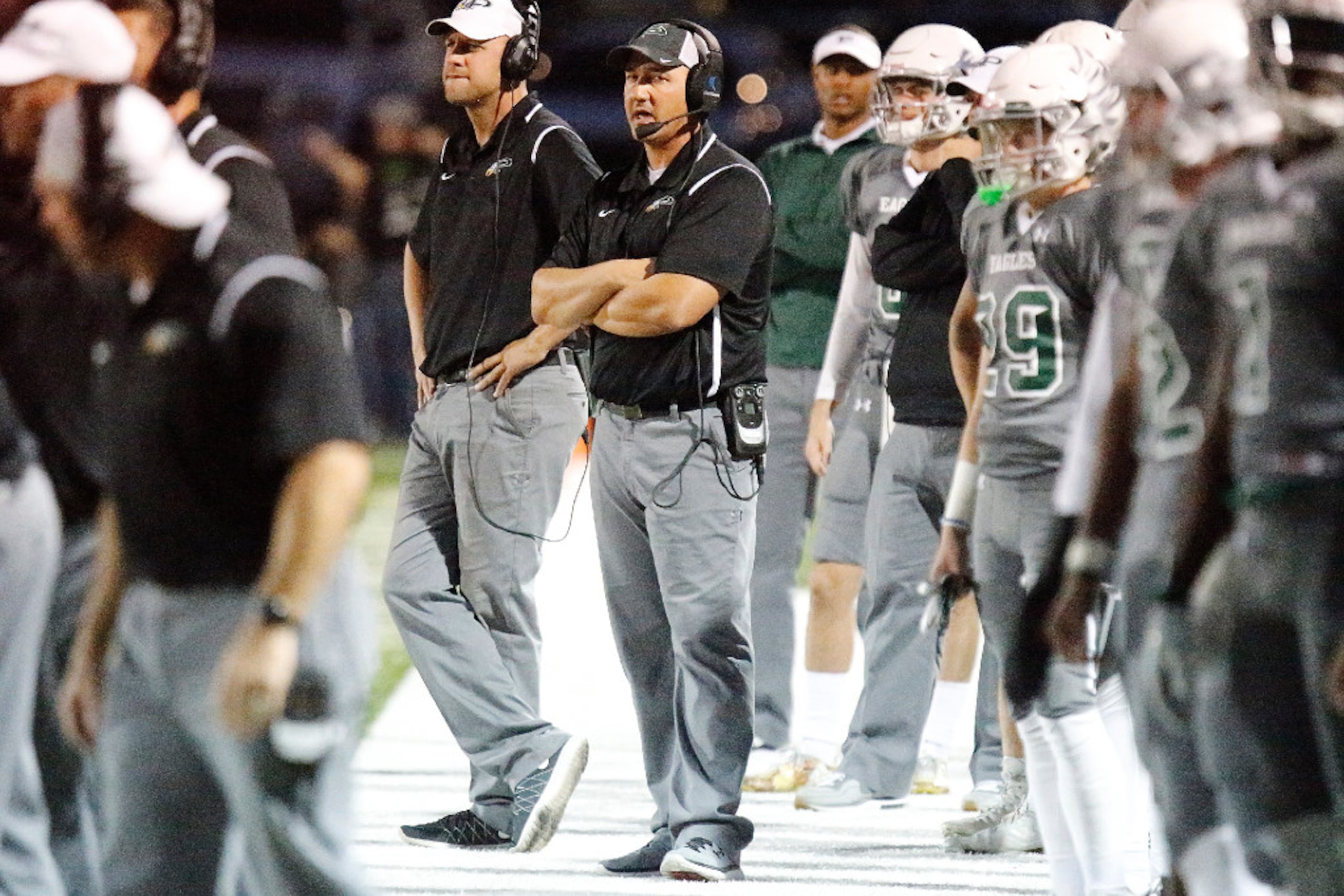 Prosper High School Head Coach Brandon Schmidt talks to his coaches in the press box during...