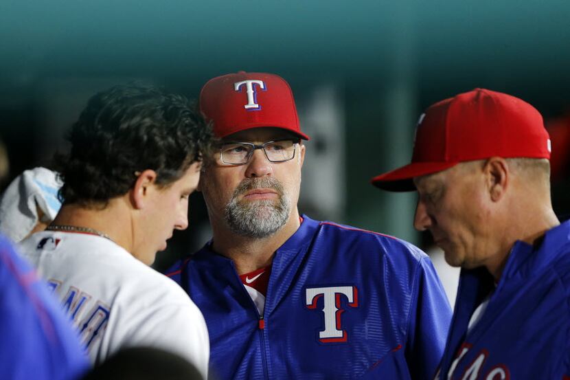 Texas Rangers pitching coach Doug Brocail (center) visits with starting pitcher Derek...