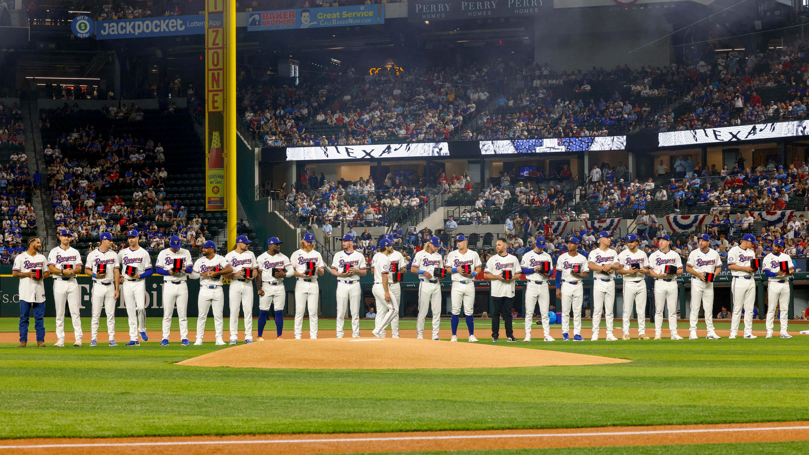 The 2023 World Series champions Texas Rangers stand on the field after being presented with...