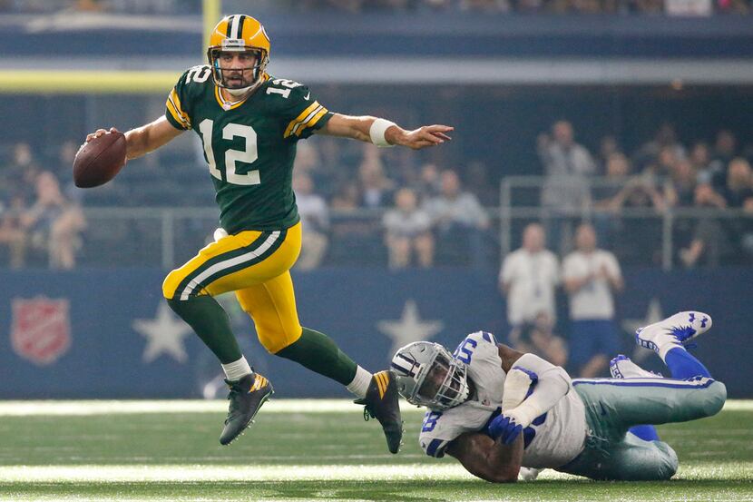 Green Bay Packers quarterback Aaron Rodgers (12) scrambles away from a Dallas Cowboys...