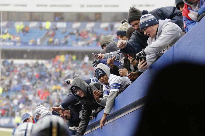Dallas Cowboys fans cheer on their team as they take the field before playing the Buffalo...