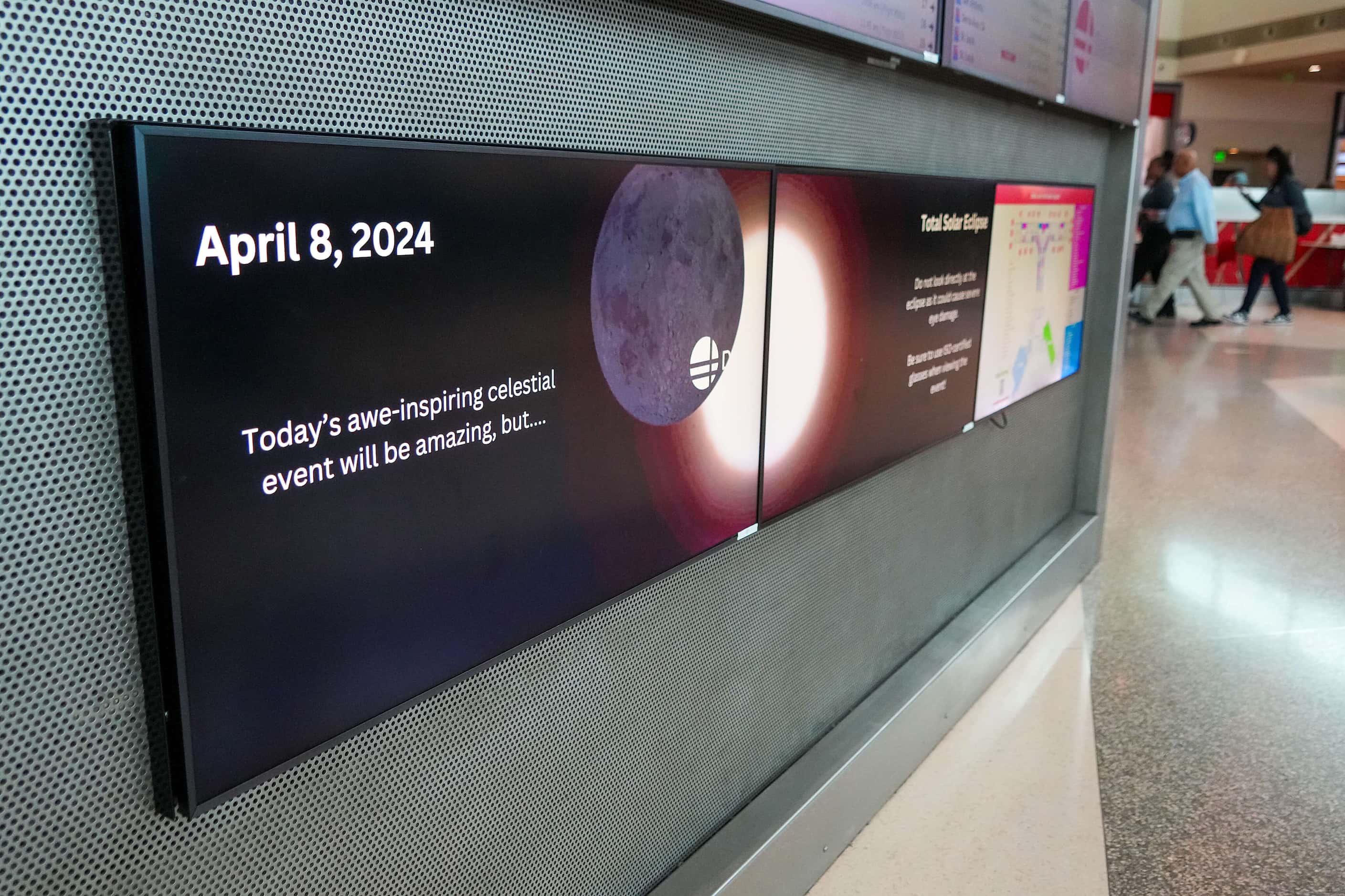 Signs promote total solar eclipse at Dallas Love Field on Monday, April 8, 2024.