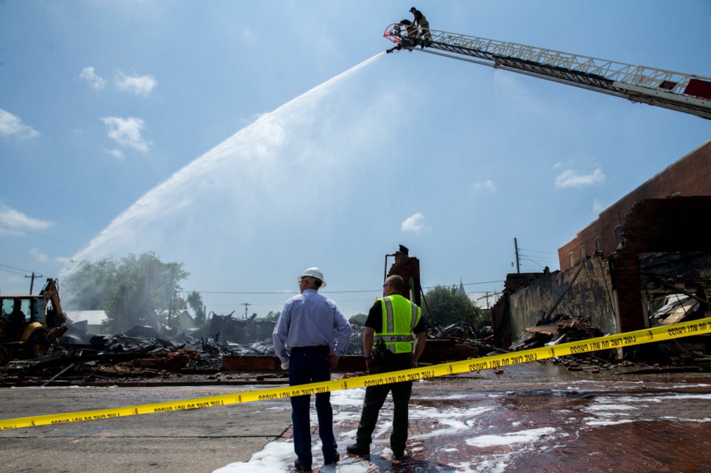 Farmersville City Manager Ben White(left) surveys the ruins after a fire burned down the...