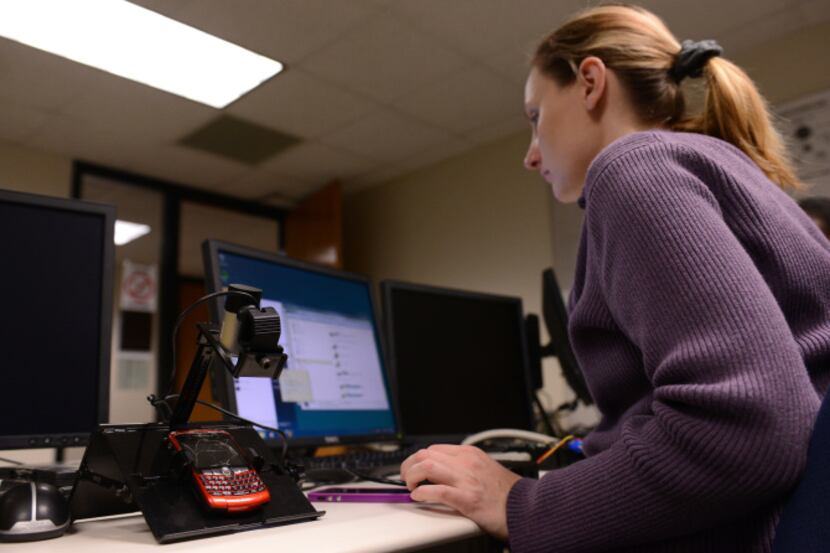Richland College student Holly Horter pulls information from a cellphone in her digital...