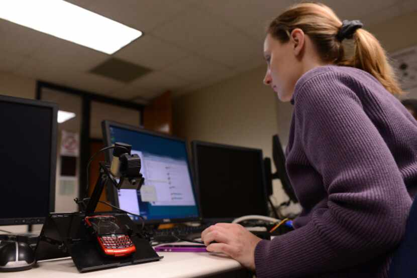 Richland College student Holly Horter pulls information from a cellphone in her digital...