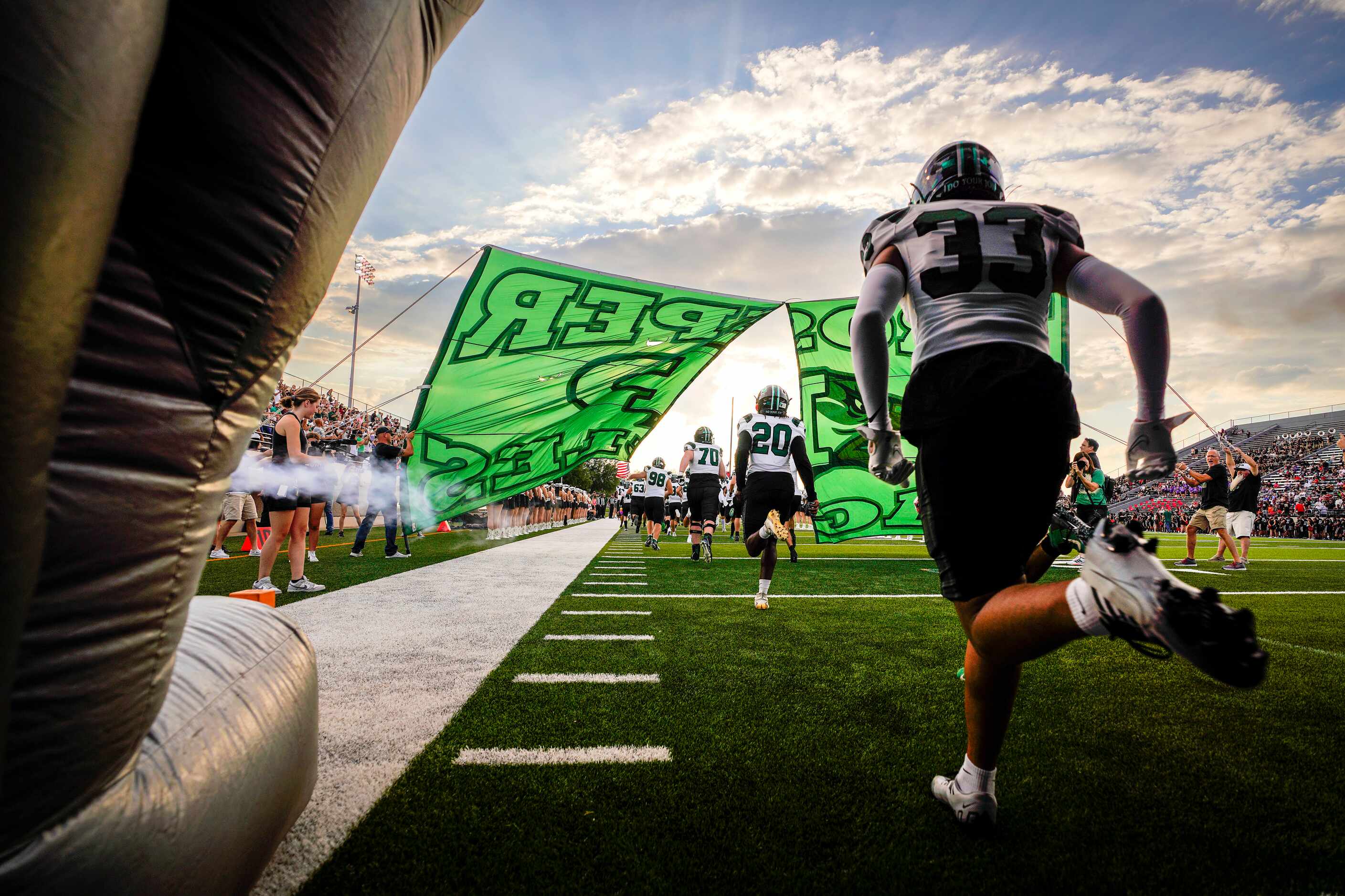 Prosper’s TJ Jones (33) runs out of the tunnel with teammates before a season-opening high...