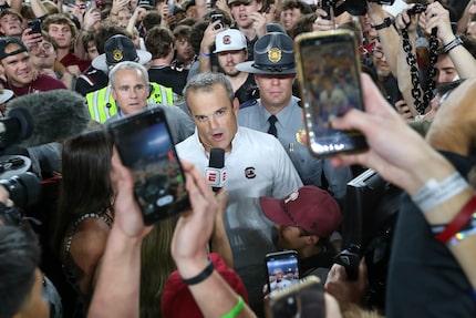 South Carolina head coach Shane Beamer gives an interview to ESPN while fans storm the field...