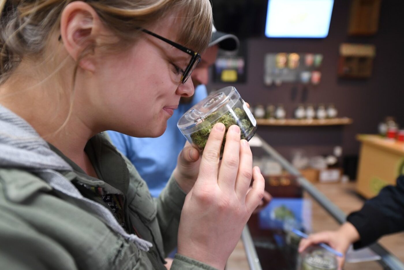 Laura Torgerson, visiting from Arizona, smells cannabis buds at the Green Pearl Organics...