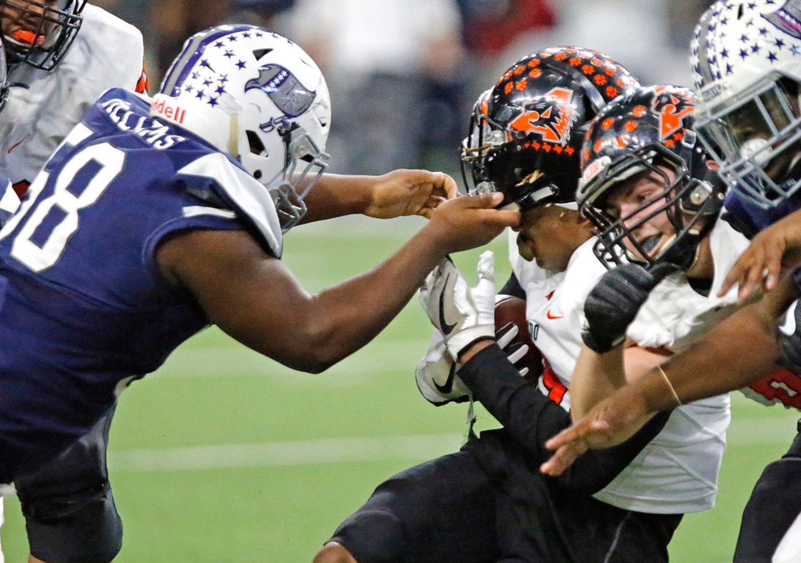 Richland High School defensive tackle Doron Williams (58) lifts the helmet off of Aledo High...