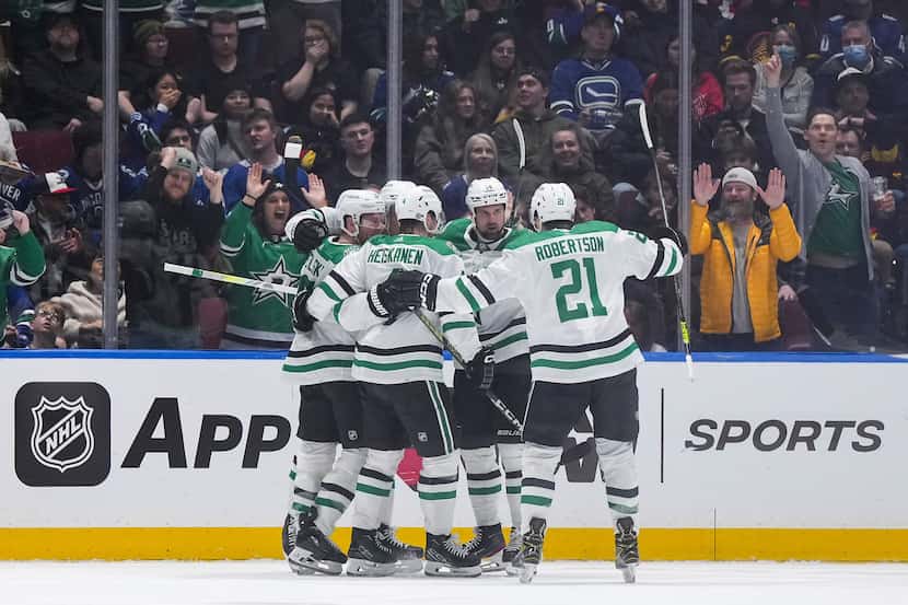 Dallas Stars' Jamie Benn, back right, celebrates his goal against the Vancouver Canucks with...
