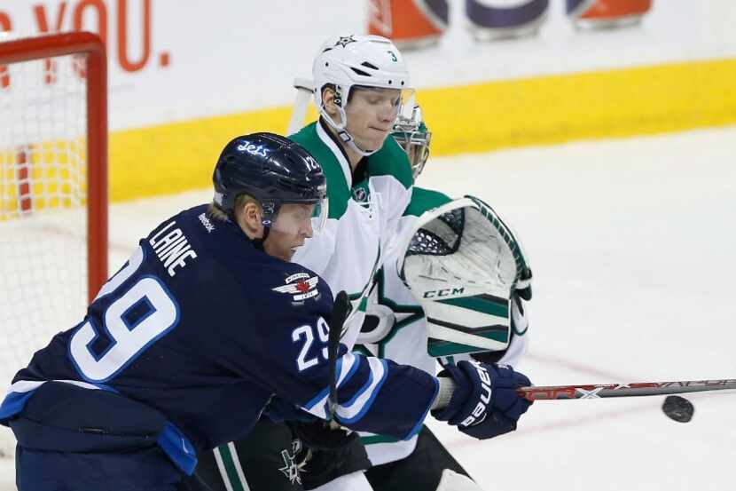 Winnipeg Jets' Patrik Laine (29) deflects a shot from the point to score on Dallas Stars...