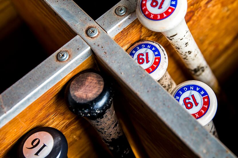 Bats of Texas Rangers players in the dugout before a spring training game against the San...