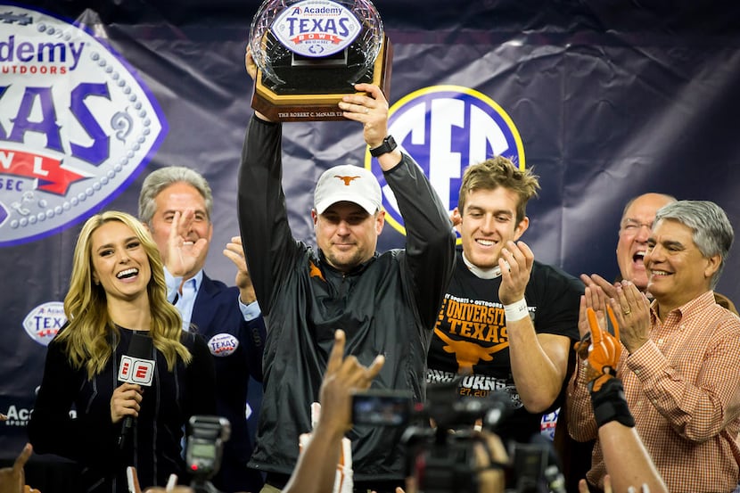 Texas head coach Tom Herman raises the championship trophy after a win over Missouri in the...