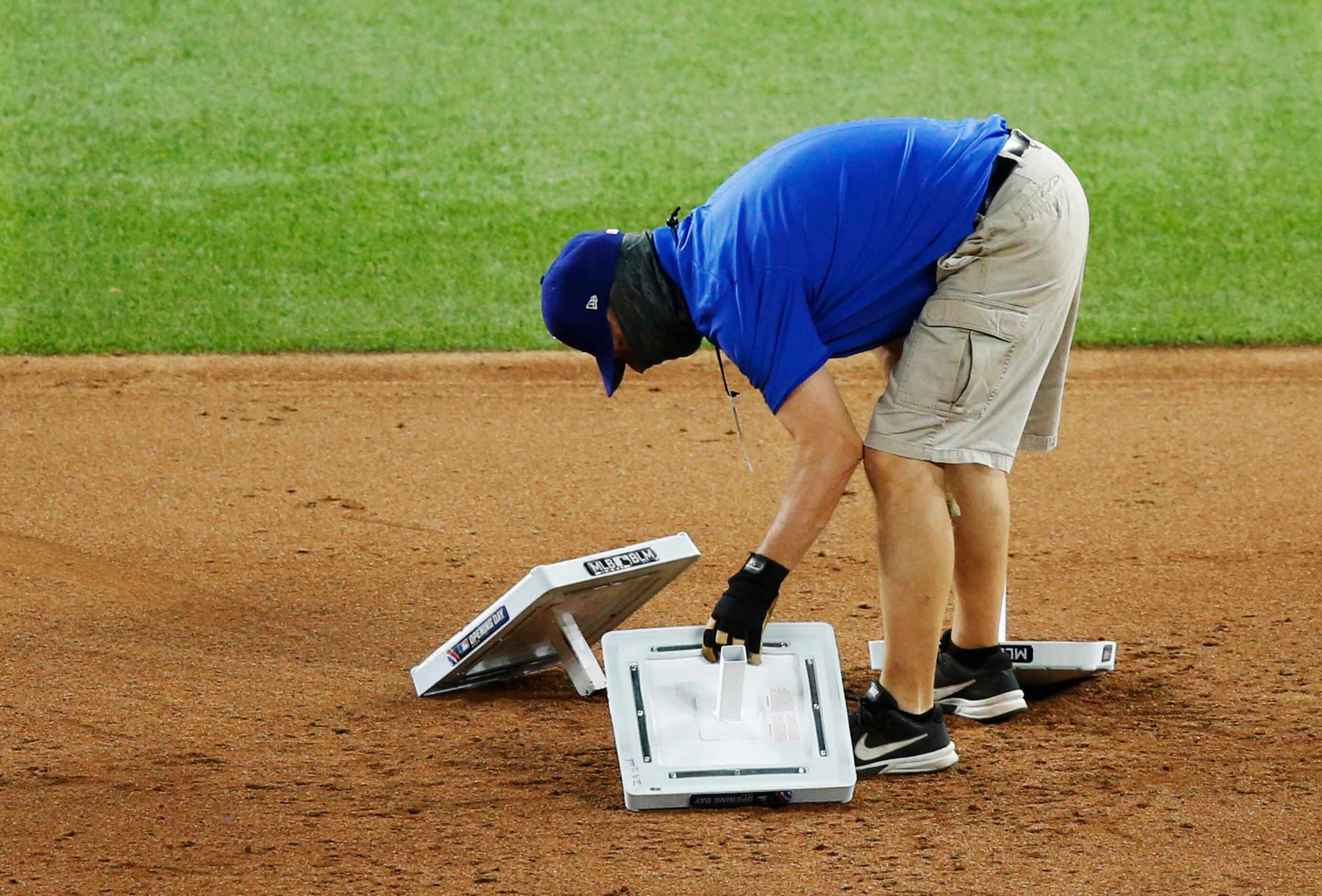 Texas Rangers grounds crew switch out plates before the start of the ninth inning in a game...