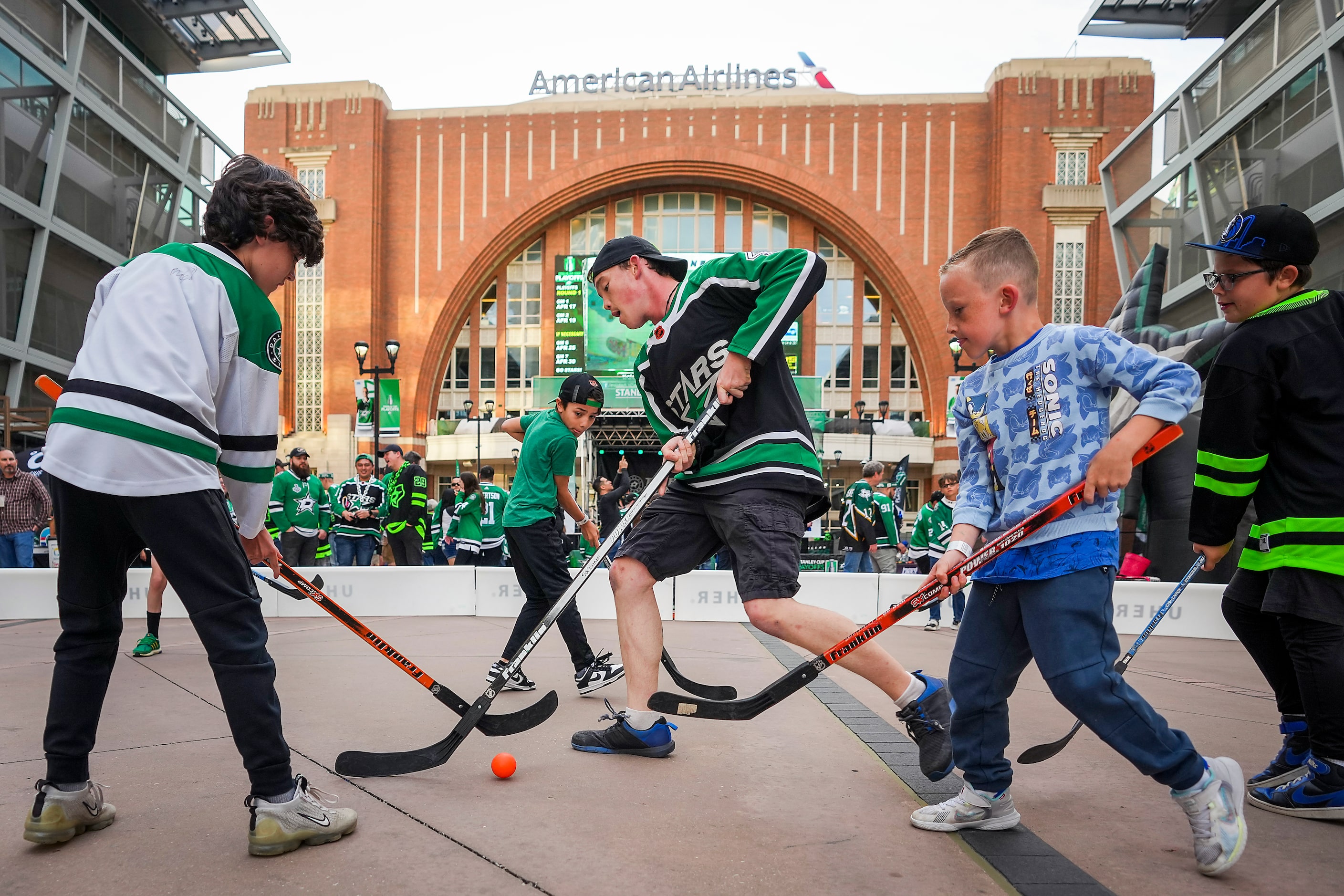 Connor Parys (center) joins other fans playing street hockey on the plaza in Victory Park...