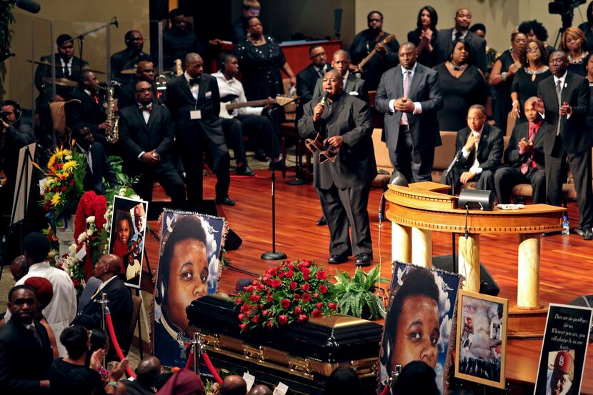 FILE - Pictures of Michael Brown flank his casket during his funeral, Aug. 25, 2014, at...