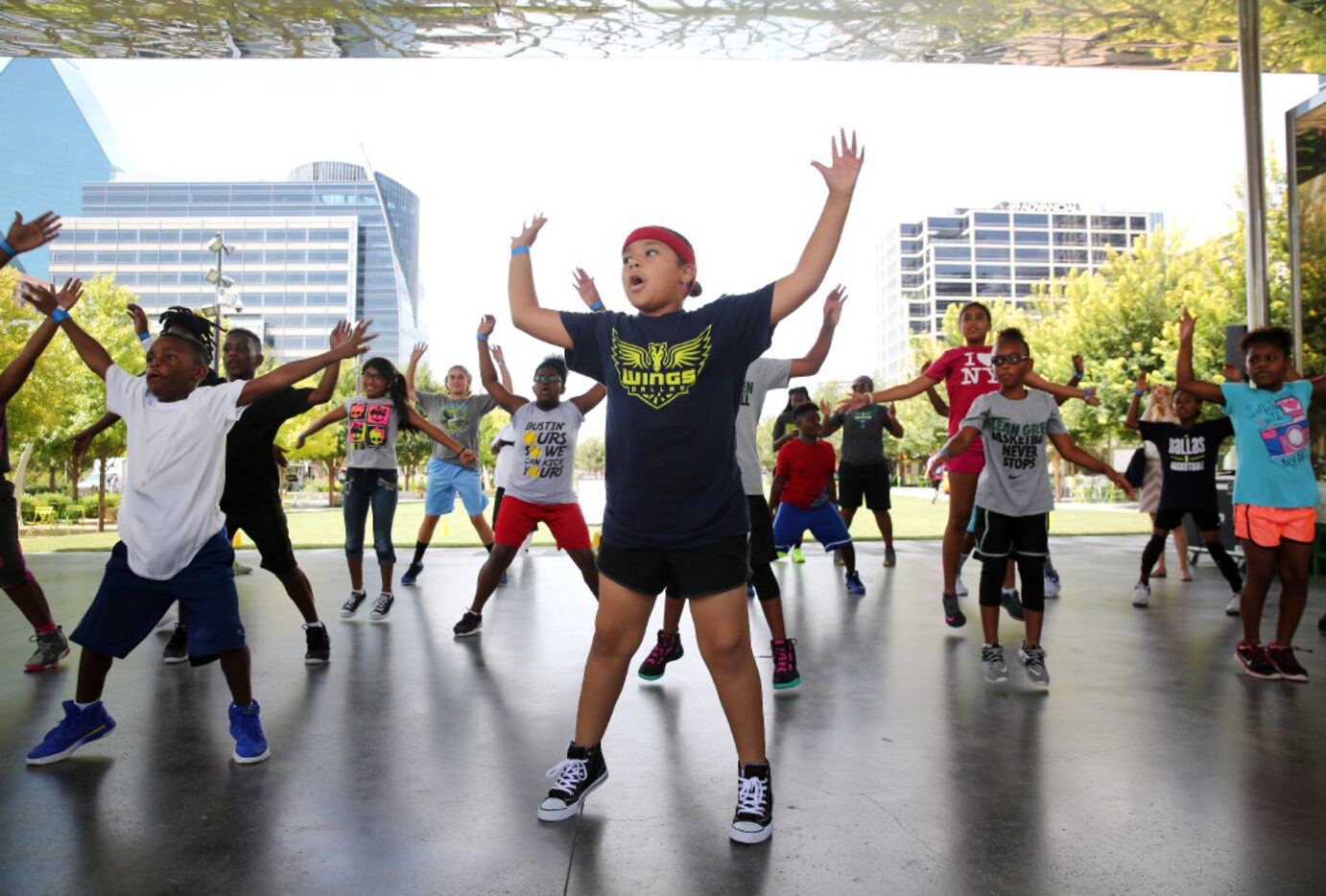 Oksana Hunter, 7, warms up other members of a basketball clinic by the Dallas Wings.  The...