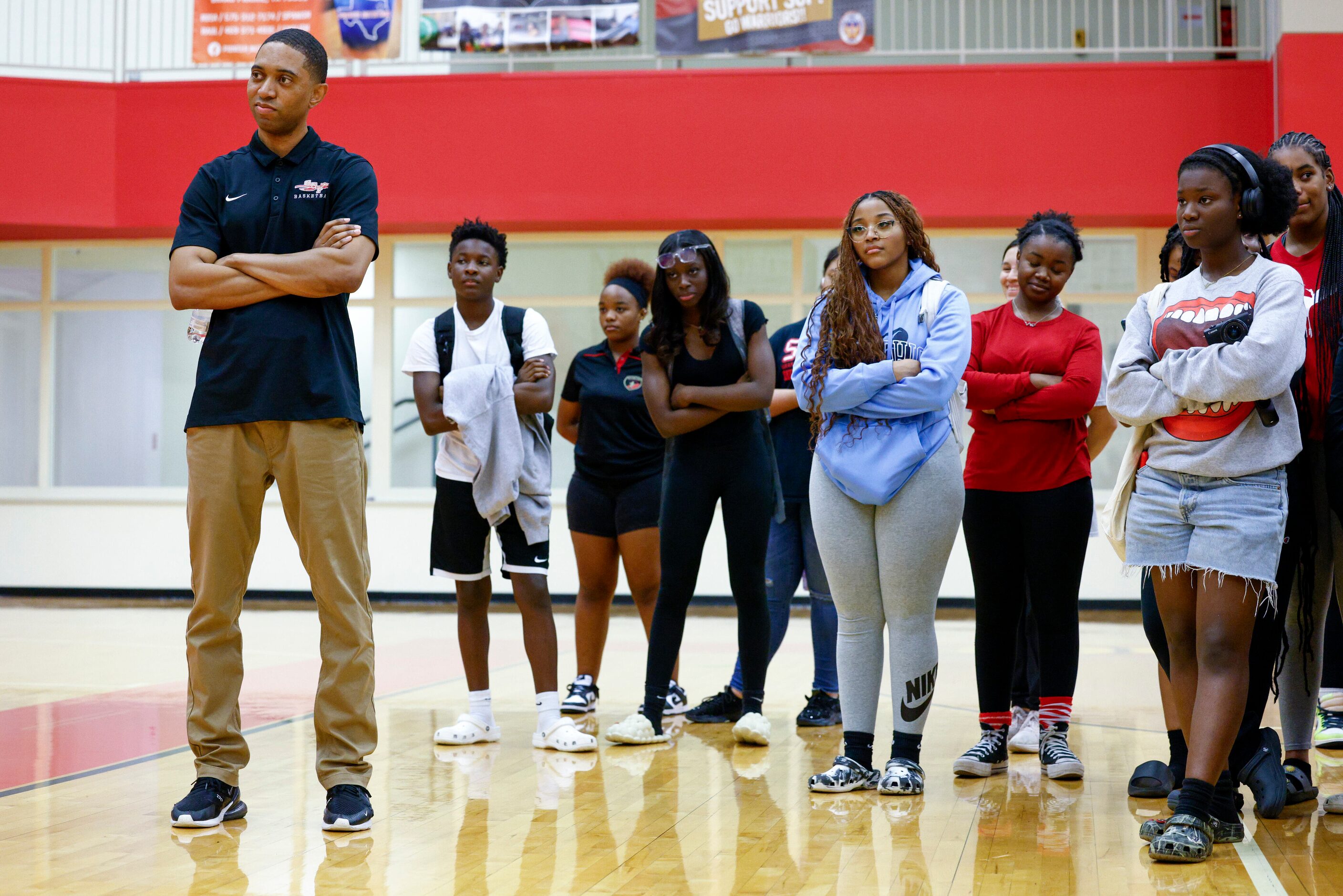 South Grand Prairie girls basketball coach Brion Raven listens as players speak during a...