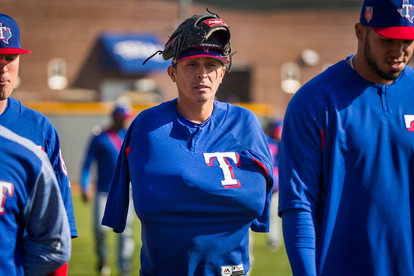 Texas Rangers pitcher Jesse Chavez bundles up against a chilly morning as he takes the field...