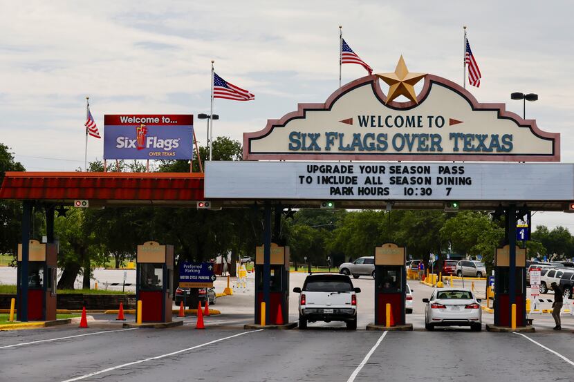 U.S. flags fly on the "Welcome to Six Flags Over Texas" sign on Aug. 18, 2017 in Arlington,...