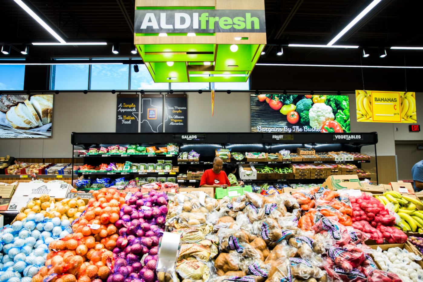 Shoppers browse the produce section of a newly renovated Aldi grocery store on Gaston Avenue...