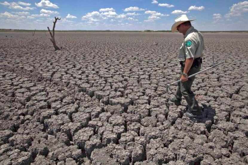 
Texas parks officer Thomas Bigham inspected the cracked bed of O.C. Fisher Lake at San...