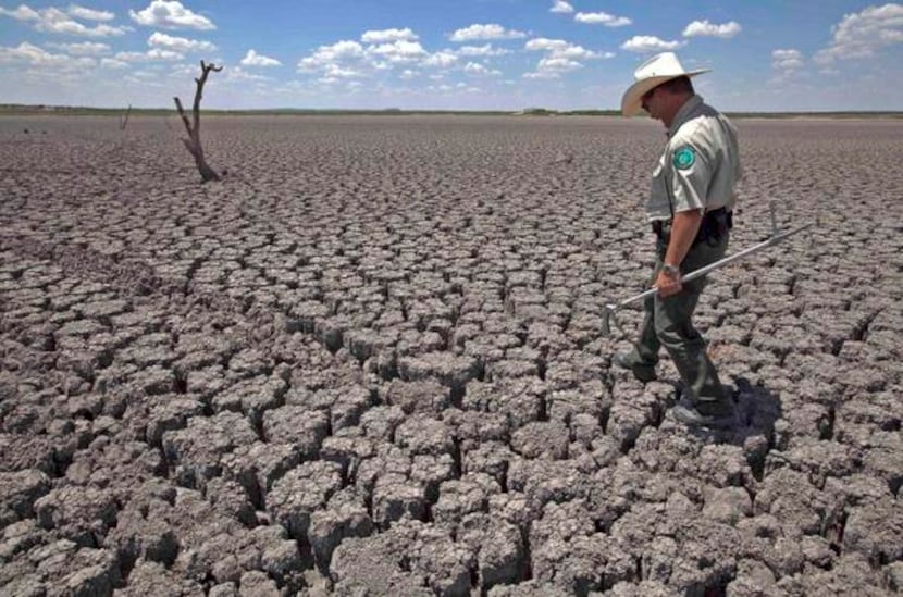 
Texas parks officer Thomas Bigham inspected the cracked bed of O.C. Fisher Lake at San...