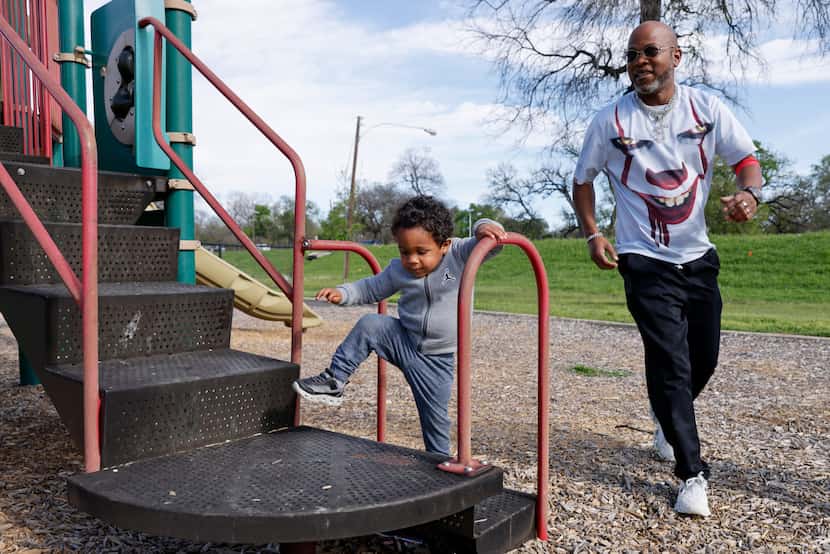 Two-year-old Messiah Watkins climbs onto playground equipment as his grandfather, Bryant...