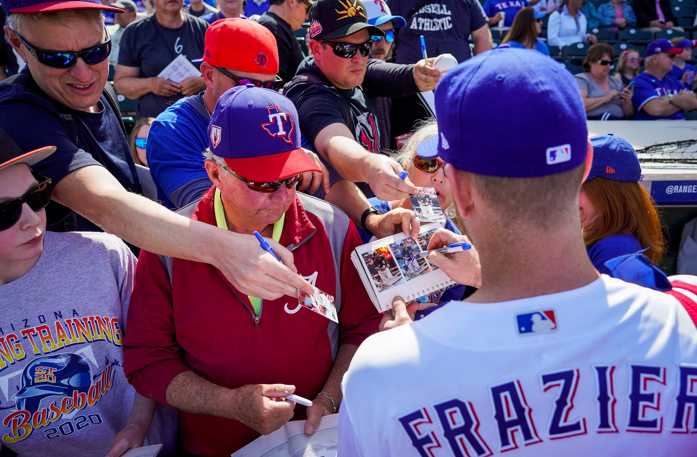 Texas Rangers third baseman Todd Frazier signs autographs before of a spring training game...