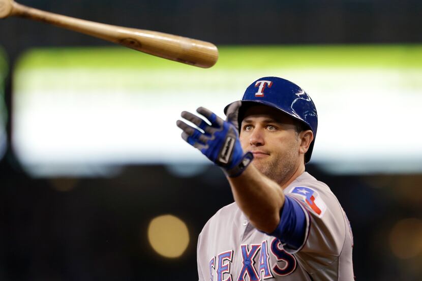 Texas Rangers' Lance Berkman tosses his bat after striking out against the Seattle Mariners...