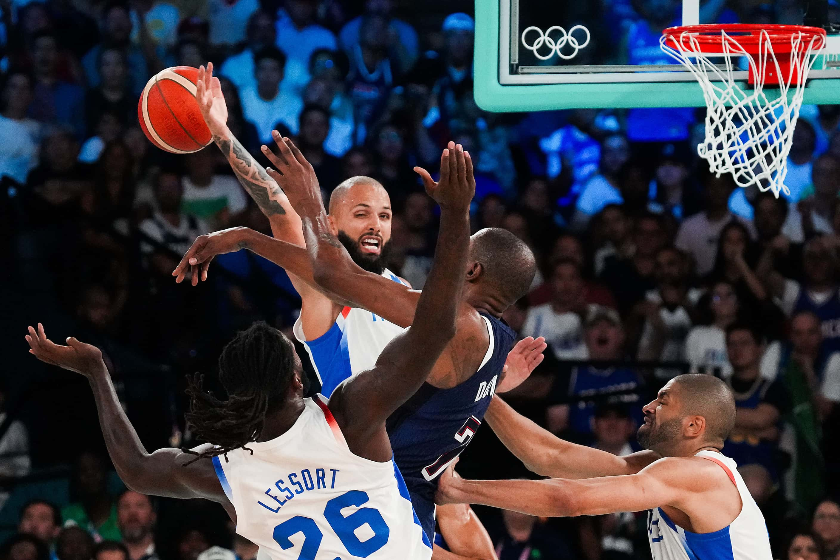 Kevin Durant (7) of the United States fights for the ball against Evan Fournier (center)...