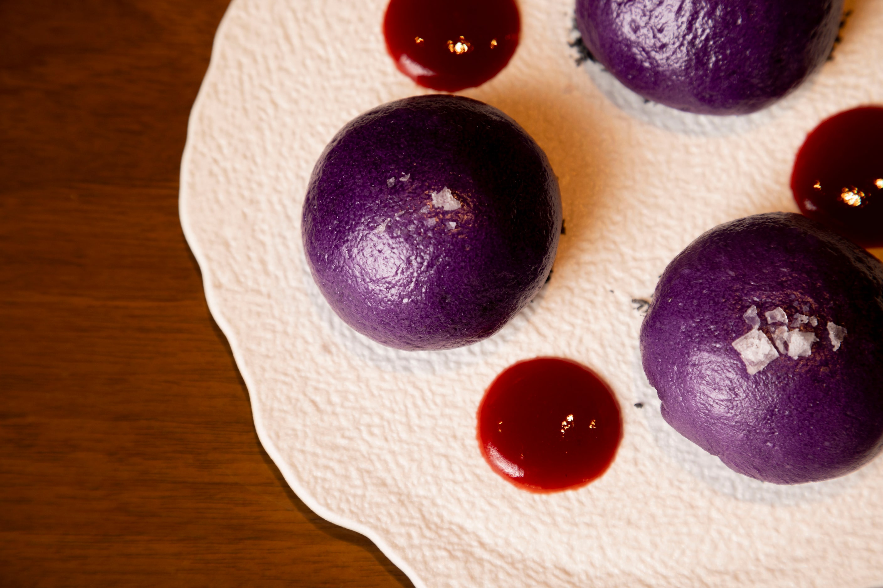 The dessert Ube Nutella Bao is prepared with coconut charcoal, strawberry sauce, sea salt at...