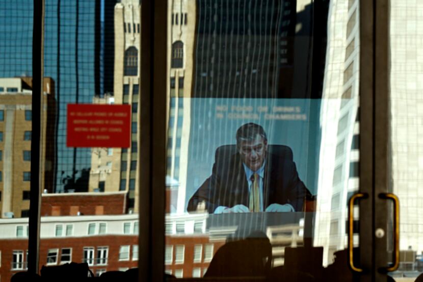  Dallas Mayor Mike Rawlings opens up the city council meeting in the reflection of the outer...