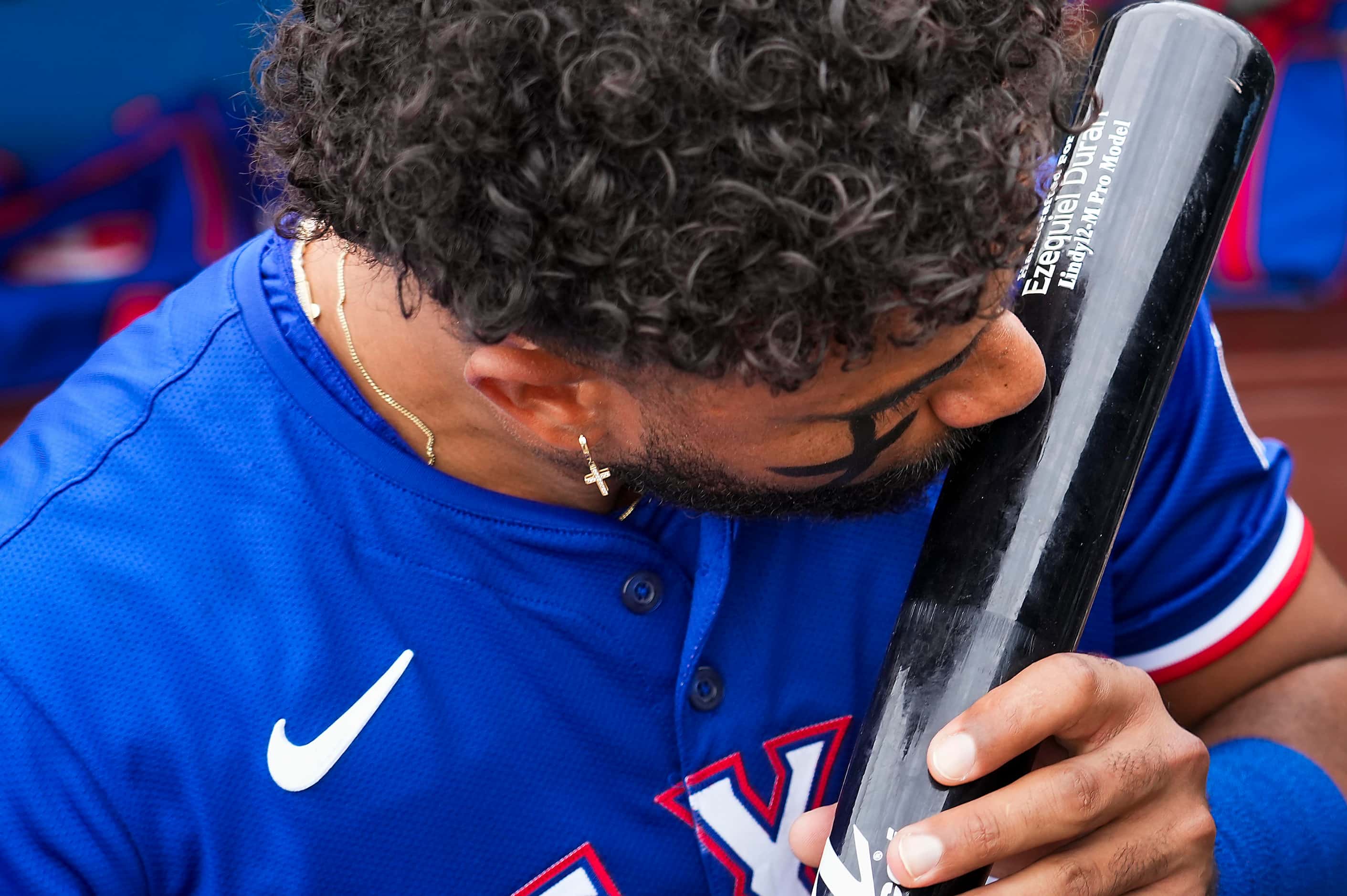 Texas Rangers Ezequiel Duran kisses his bat in the dugout before a spring training game...
